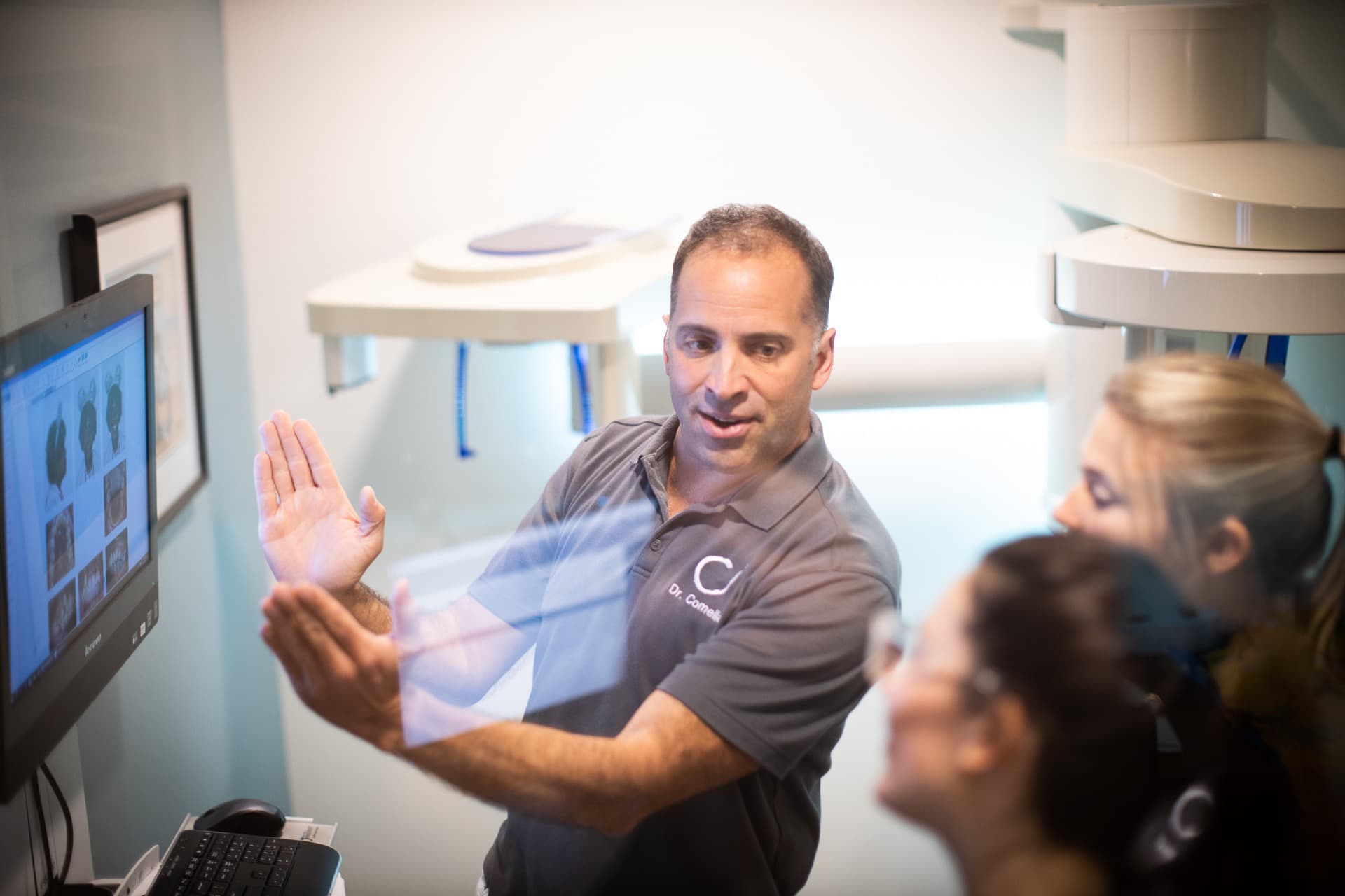 Comella Orthodontics Rochester New York Dr Comella Candids-53 Dr. Comella showing a patient orthodontic retainers at our Rochester, NY office
