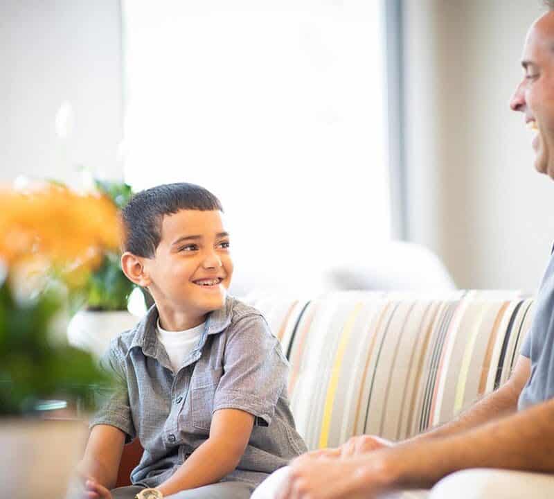 Dr. Comella talking with a young boy about early orthodontic treatment in Rochester, NY